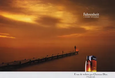 This is a print advertisement for Fahrenheit Eau de Toilette by Christian Dior, sold at Macy's. The image shows a wooden pier extending into a misty, orange-hued body of water at sunset, with a lone silhouetted figure standing at the far end of the pier. In the bottom right corner, the amber-colored perfume bottle and its box are displayed.