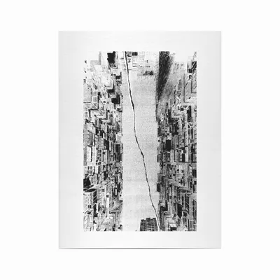 A black and white print or artwork showing a densely packed urban cityscape of tall residential or commercial buildings viewed from street level looking upward, with a jagged diagonal crack or tear running through the center of the image, creating a split effect. The buildings are rendered with a grainy, high-contrast texture.